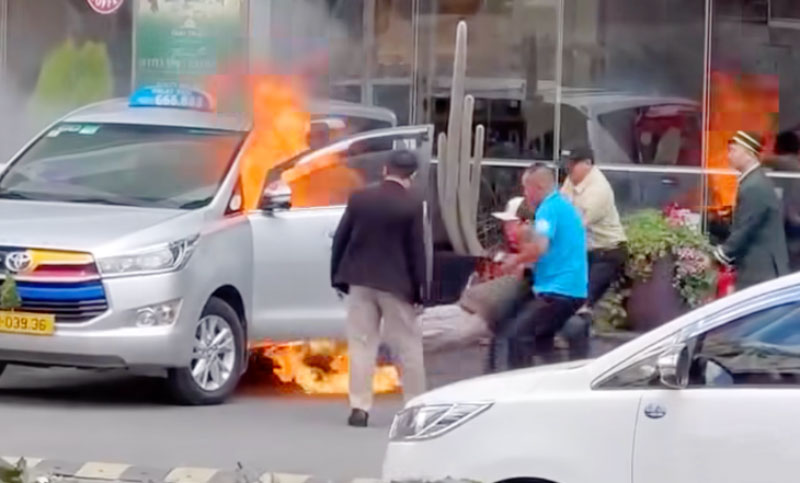 Tài xế được đưa ra khỏi xe đang bốc cháy - Ảnh: Cắt từ video clip bao-ve-giai-cuu-tai-xe-taxi-1